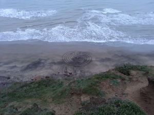 Elevated view of a labyrinth drawn in the tidal zone at Compton Beach, Isle of Wight